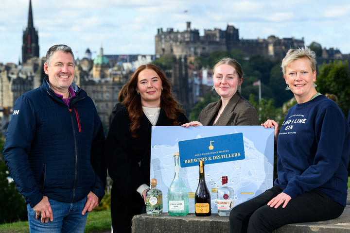 4 people stood at the top of Calton Hill holding the Meet Edinburgh's Makers Map