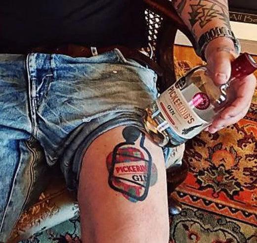 Tattoo of Pickering's Gin on someones thigh