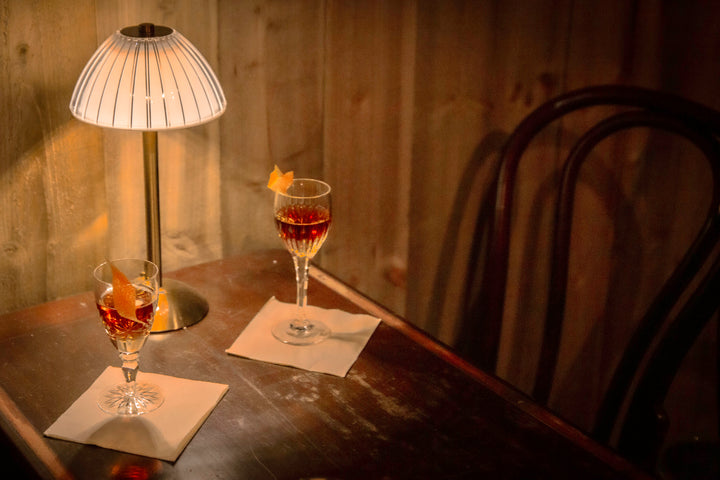 Two cocktails on a dimly lit table
