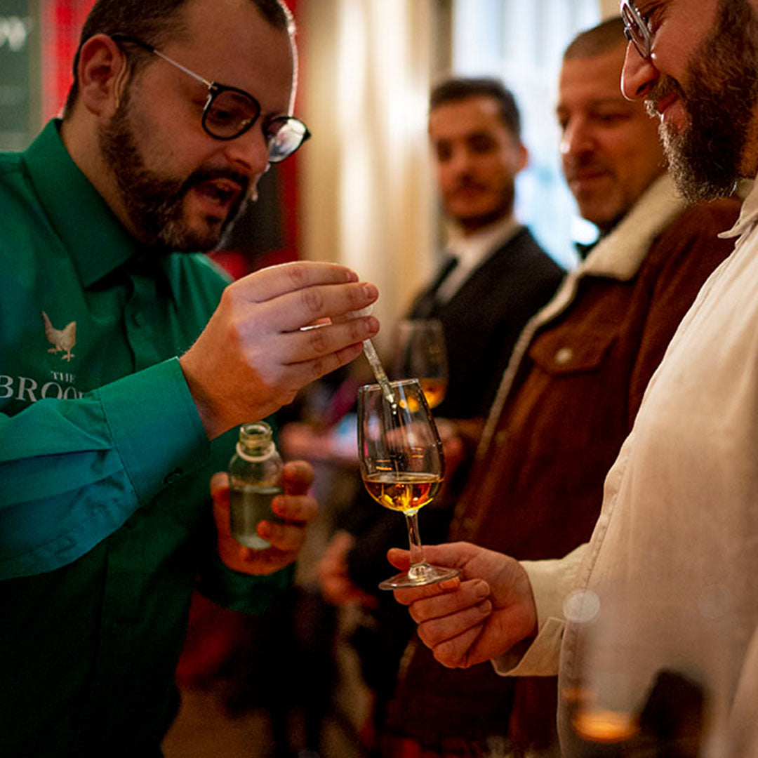 Someone adding a drop of water to their Broody Hen dram