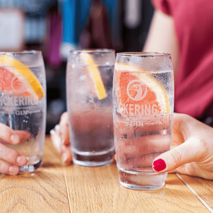 Three people holding Pickering's Gin & Tonic glasses