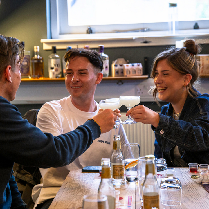 Three people cheersing cocktails