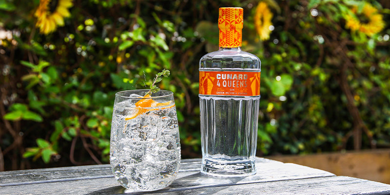 Bottle of 4 Queens Elizabeth Gin next to a G&amp;T