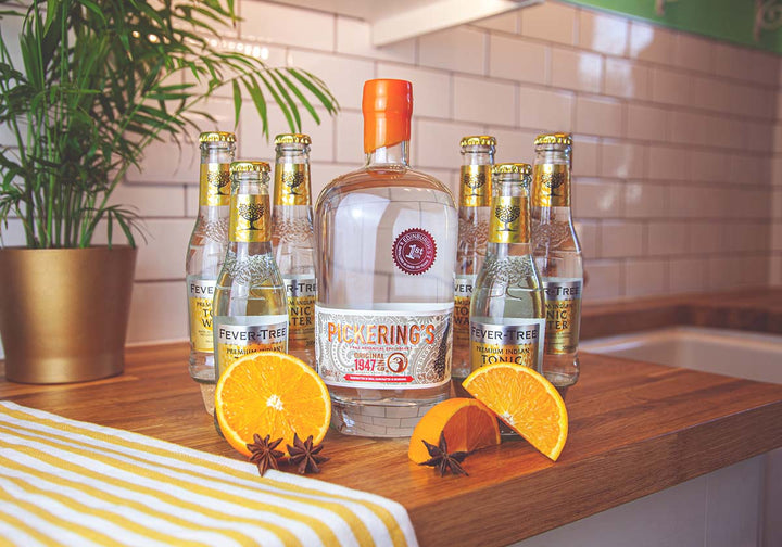 Bottle of Pickering's Gin surrounded by tonic and oranges