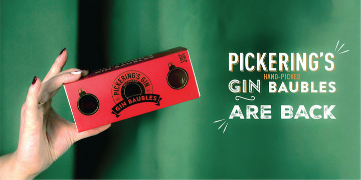Red box labeled 'Pickering's Gin Baubles' held by a hand against a green background with promotional text.