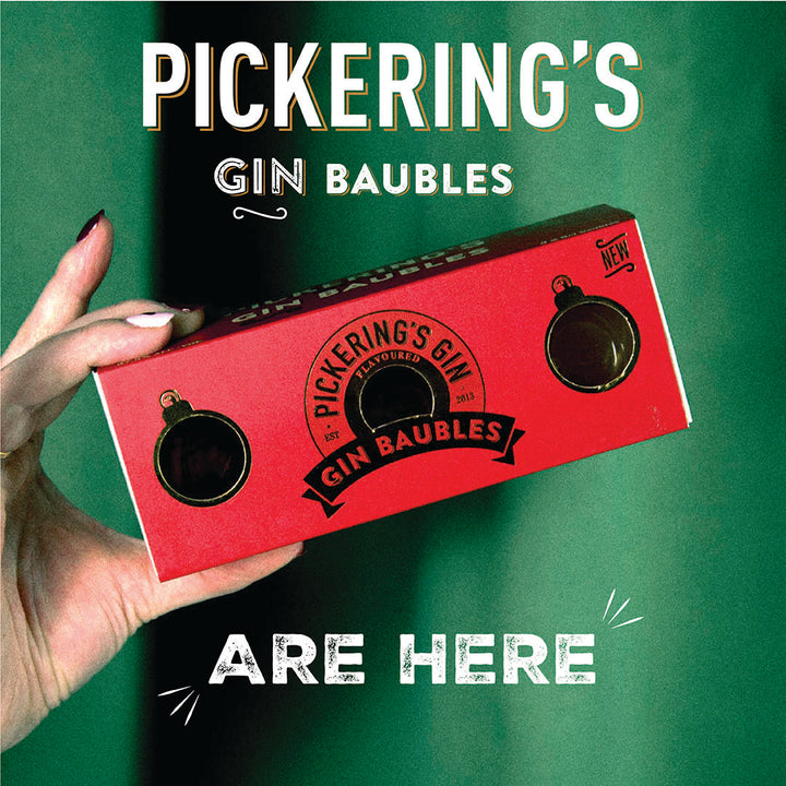 Red box labeled 'Pickering's Gin Baubles' held by a hand against a green background with promotional text.