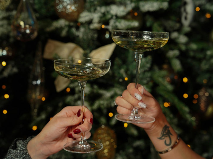 Two people holding cocktails